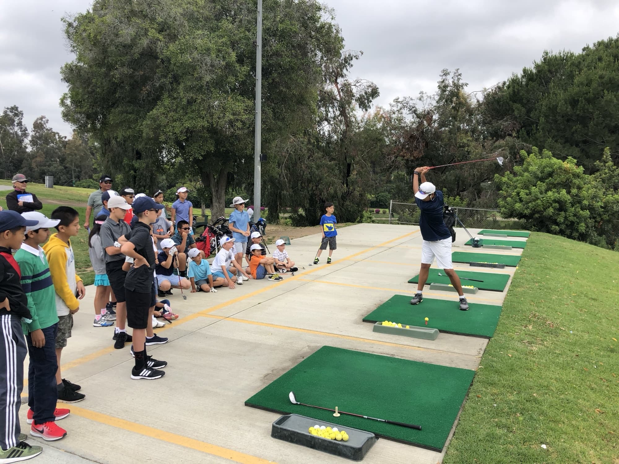 A Jucchou Golf coach demonstrating a swing for juniors at the driving range